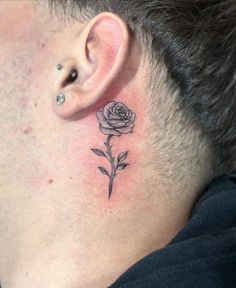 a man with a small tattoo on his neck and behind the ear is a single rose