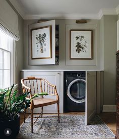 a washer and dryer in a room with pictures on the wall above it