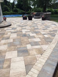 an outdoor patio with stone pavers and seating area