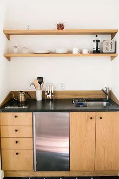 a stainless steel dishwasher sitting on top of a kitchen counter next to wooden cabinets