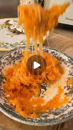 someone is sprinkling shredded carrots on a plate