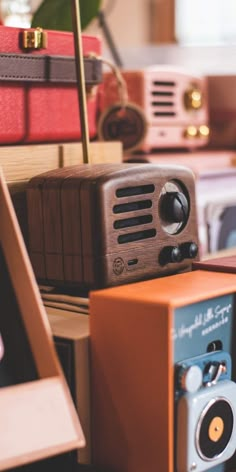 an old fashioned radio sitting on top of a wooden table next to other electronics and boxes