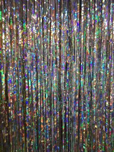 an abstract background made up of multicolored glass beads and metallic rods with lots of light shining through them