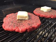 two hamburger patties cooking on a grill