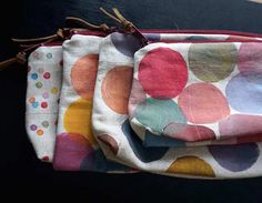 three colorful polka dot bags sitting on top of a black table next to each other