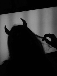 the silhouette of a woman with horns on her head