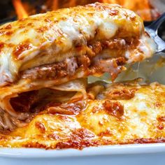 a close up of a plate of food with meat and cheese on it next to a fire