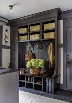 a mud room with gray cabinets and baskets