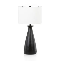 a black table lamp with a white shade on the base and a light in front of it