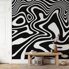 a black and white abstract wallpaper in a living room with a wooden coffee table