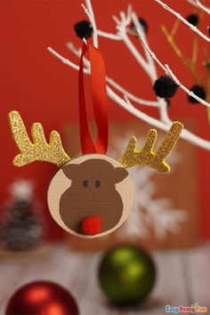 a christmas ornament hanging from a tree with red and gold ornaments in the background