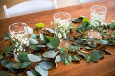 the table is covered with greenery and candles