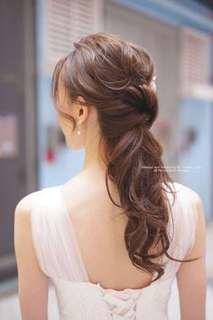 a woman with long brown hair wearing a white dress and looking at something in the distance