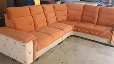 an orange and white couch sitting on top of a floor