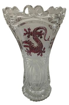 a glass vase with a red dragon on it