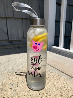 a water bottle with a pig face painted on it and the words out on some water