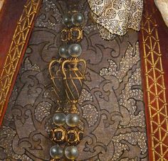 an ornately decorated table cloth with gold and silver decorations on it's edge