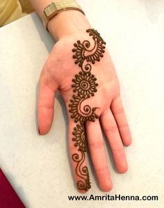 a woman's hand with a henna tattoo on it