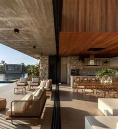 an outdoor living area with couches and tables next to the water's edge