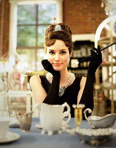 a woman sitting at a table with a cup and saucer