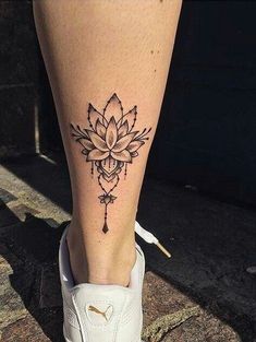 a woman's foot with a flower tattoo on the side of her leg,