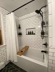 a white bathroom with black and white tile on the floor, shower curtain, and bathtub