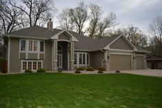 a house that is in the middle of a yard with grass and trees around it