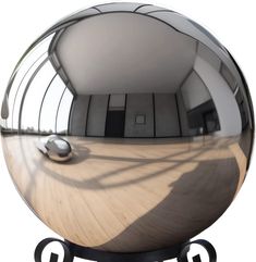 a mirror ball sitting on top of a wooden table next to a metal stand with a computer mouse