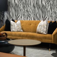 a living room filled with furniture and zebra print wallpaper