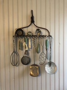 a wall mounted rack with various kitchen utensils hanging from it's sides