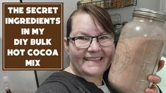 a woman holding a jar with hot cocoa in it and the caption reads, the secret ingredients in my diy bulk hot cocoa mix