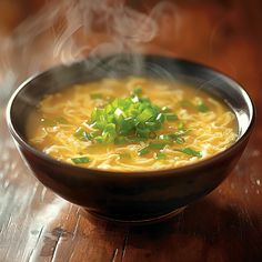 a bowl of soup with noodles and green onions