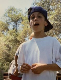 a young boy wearing a blue hat and white shirt