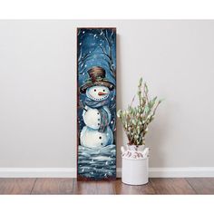 a snowman standing next to a potted plant in front of a painting on the wall