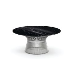 a black marble table with metal base on a white background in the style of knoll