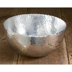 a metal bowl sitting on top of a wooden table