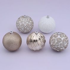 six different ornaments are shown in white and silver on a purple background, including one with an ornament