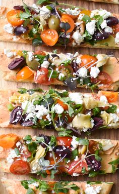 four flatbreads with different types of vegetables on them and some feta cheese