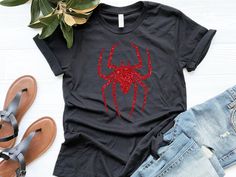 You're going to love our Spider Shirt. It's a unique and festive piece that you'll want to wear for years. The design is perfect for the Halloween costume party, trick-or-treating, or might even be a great addition to your wardrobe year-round. This comfortable t-shirt will be your and your friends' favorite! Be simple, be different! M A T E R I A L S → All our simple color ones like White and Black are 100% Cotton. → All our Heathered Colors are cotton/polyester blend and they are super comfy soft! → Bella-Canvas Unisex Jersey Short Sleeve Crew-Neck Unisex T-Shirt → Soft and High-Quality Fabric → Sueded Jersey → Pre-shrunk → Taped shoulder-to-shoulder → Tear away label → Side Seamed → Retail fit S I Z E → We have a size chart on our listing photos. S H I P P I N G & P R O D U C T I O N T I Black Glitter T-shirt With Short Sleeves, Black Crew Neck T-shirt With Glitter Print, Black Glitter Short Sleeve T-shirt, Spider Shirt, Spiderman Shirt, Spider Costume, Halloween Costume Party, Black Spider, T Shirt Costumes