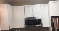 a kitchen with white cabinets and stainless steel appliances