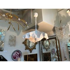 a chandelier hanging from the ceiling in a room with mirrors and other items