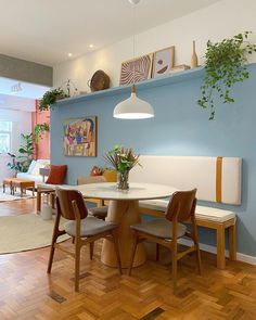 a dining room with blue walls and wooden flooring is seen in this image, there are several chairs around the table