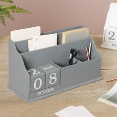 a desk with a pen, eyeglasses and calendar on it