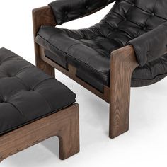 a black leather chair and footstool sitting next to each other