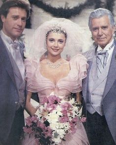 two men and a woman in formal wear posing for a photo on their wedding day