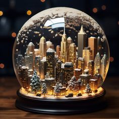 a snow globe with buildings and trees in the city at night, on a wooden table