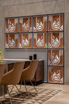 a dining room table with four chairs in front of an art work on the wall