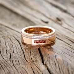 a close up of a wedding ring on a wooden surface