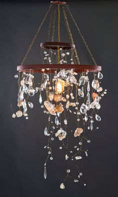 a chandelier hanging from the ceiling with crystal beads and chains attached to it