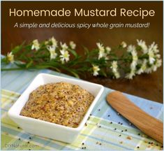 homemade mustard recipe in a small white bowl on a blue and green tablecloth with flowers